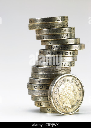 A pile of British pound coins with one by the side Stock Photo