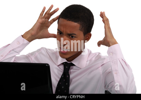 Stress young businessman sat at computer Stock Photo