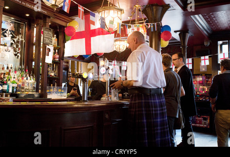 A scotsman in a kilt ordering a drink at the bar of the Duke of York pub, Victoria, London UK Stock Photo