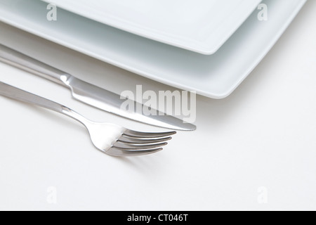 Place setting. white china plates with silver knife and fork Stock Photo