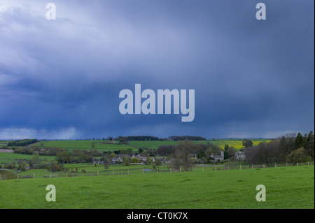 Rainstorm from Cumulonimbus cloud above Asthall Village in springtime in the Cotswolds, Oxfordshire, UK Stock Photo