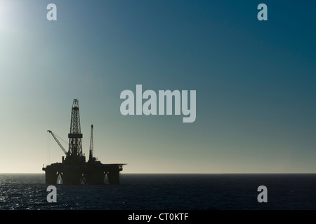 silhouette of an offshore oil drilling rig in low light sunset/sunrise time. Coast of Brazil Stock Photo