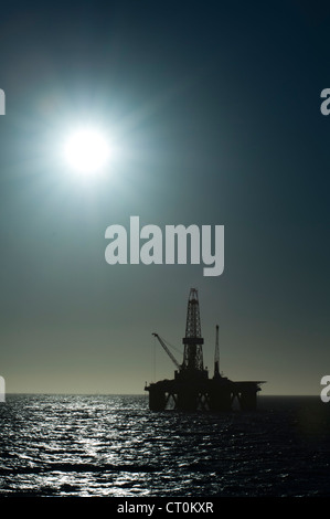 silhouette of an offshore oil drilling rig in low light sunset/sunrise time. Coast of Brazil Stock Photo