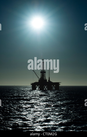 silhouette of an offshore oil drilling rig in low light sunset/sunrise time. Coast of Brazil Stock Photo