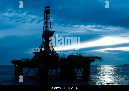 silhouette of an offshore oil drilling rig in low light sunset/sunrise time. Coast of Brazil Stock Photo