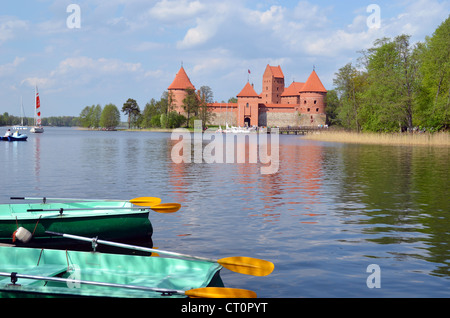 Boats on Galve lake shore and Trakai Castle in Lithuania. Floating boats and water bikes. Active outdoor recreation. Stock Photo