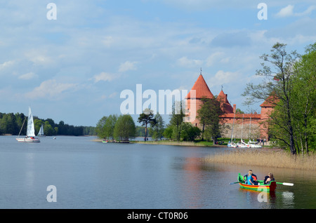 People traveling by boat on Lake Galve and Trakai Castle. XIV - XV century architecture. Most visited tourist place in Lithuania Stock Photo