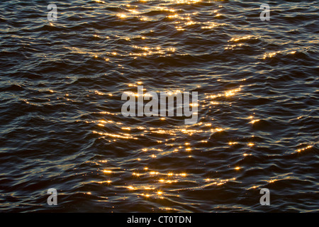Ocean ripples sparkle with the sunset rays Stock Photo