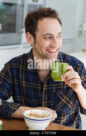 Man having breakfast at table Stock Photo