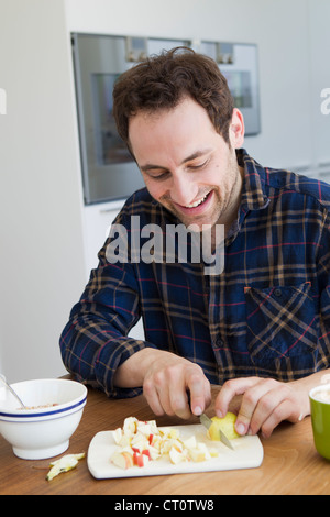 Man chopping fruit at table Stock Photo