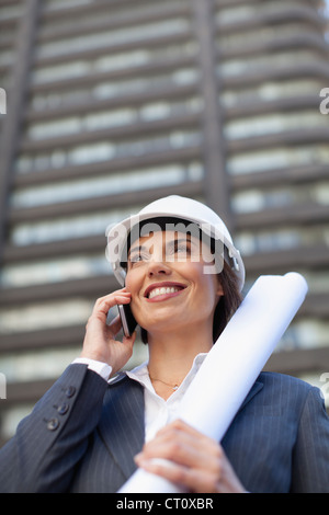 Businesswoman with blueprints outdoors Stock Photo