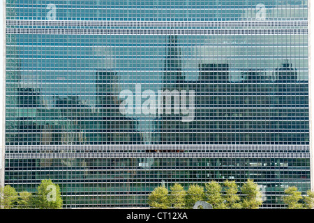 The Manhattan skyline reflected in the windows of the United Nations building in New York City, USA. Stock Photo