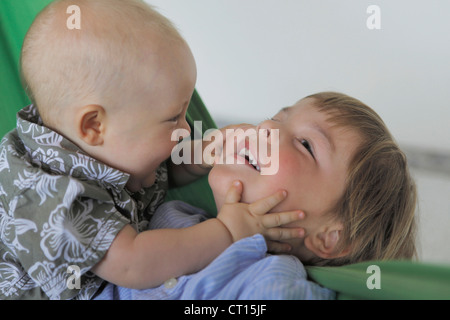 Baby boy and brother playing on couch Stock Photo