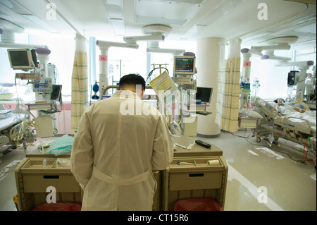 A doctor looks at patient records in the intensive care unit, Samsung Medical Centre, Korea.