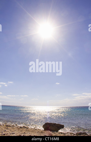 Sun shining over sandy beach Stock Photo