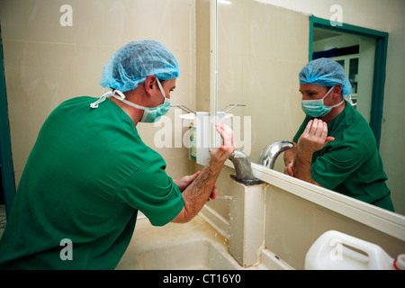 A Surgeon washes his hands and arms prior to surgery. Stock Photo