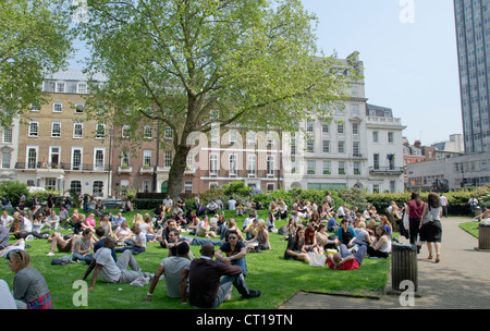 Londoners eating lunch on a sunny day in Cavendish Square Gardens Stock Photo