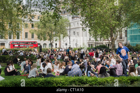 Londoners eating lunch on a sunny day in Cavendish Square Gardens Stock Photo