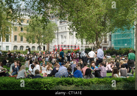 Londoners eating lunch on a sunny day in Cavendish Square Gardens Stock Photo