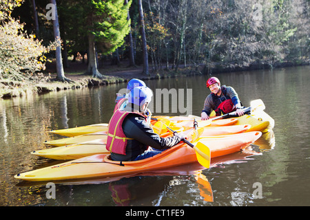 Teacher talking to students in kayaks Stock Photo
