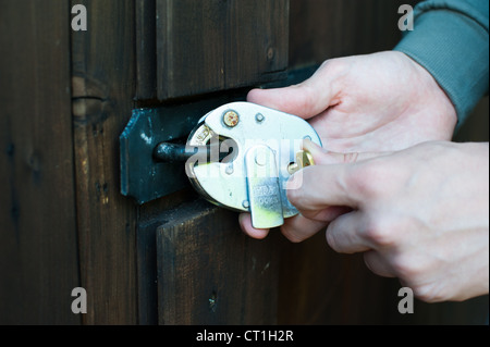 Locking a door with a padlock Stock Photo