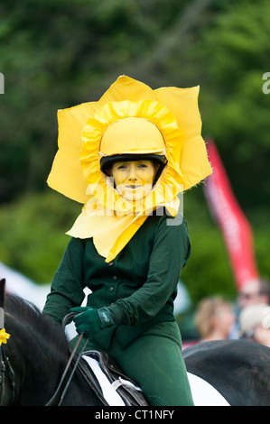 a Woman dressed as daffodils performing dressage on horse. uk Stock Photo