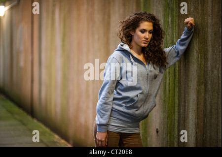 A young 20 year old slim attractive woman girl alone urban city UK Stock Photo