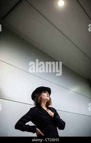 A young 20 year old slim attractive woman girl wearing a black coat and har UK Stock Photo