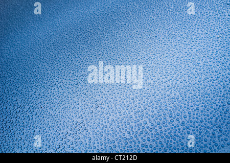drops of rain on a blue metal surface Stock Photo