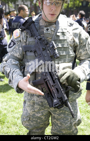 Army recruit displays the high tech standard issue M4 Carbine with grenade launcher attached at Army 237 birthday celebration Stock Photo