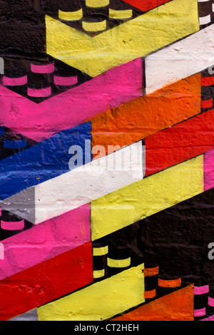Colorful graffiti of toy building bricks on a dark wall. Stock Photo