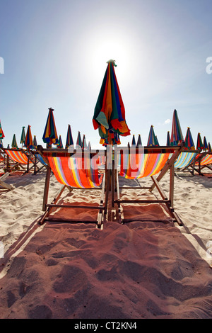Colourful beach umbrellas and deckchairs for a summer holiday on the tropical sandy beach of Khai Nok Island, Phuket, Thailand Stock Photo