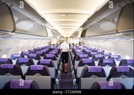 air hostess checking an empty airplane interior Stock Photo