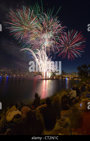 People Watching Fireworks Display Along the Banks of Willamette River in Portland Oregon Vertical Stock Photo