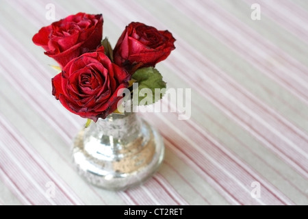Vase of colorful flowers with a red heart balloon in the background ...
