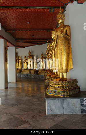 Wat Po Buddhist Temple row of gold Buddha statues standing in the Protection Position Bangkok Thailand Stock Photo