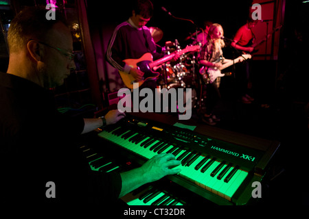 Adult keyboard player accompanies a teenage band perform band in a south London pub. Stock Photo