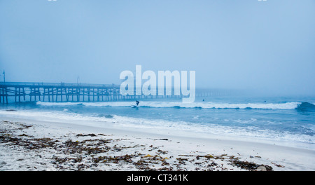 San Clemente pier with surfers on a foggy day Stock Photo