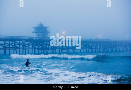 San Clemente pier with surfers on foggy day, California, USA Stock Photo