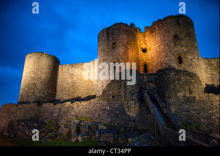 HARLECH, Wales — Harlech Castle, a 13th-century fortress built by Edward I, stands silhouetted against the dusk sky on the northwest coast of Wales. The fading light accentuates the imposing outline of this UNESCO World Heritage Site, showcasing its strategic position overlooking the Irish Sea and evoking the medieval grandeur of this historic monument. Stock Photo