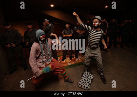 Israeli demonstrators dressed in clown outfit pose next to border policemen during Cost of Living protest  in Tel Aviv Israel. The social justice protest also named the Tents protest were a series of demonstrations in Israel beginning in July 2011 involving hundreds of thousands of protesters from a variety of socio-economic opposing the continuing rise in the cost of living particularly housing. Stock Photo