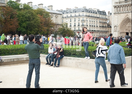 Paris, France - Couple taking photos with digital tablet in front of Notre Dame Cathedral. Stock Photo