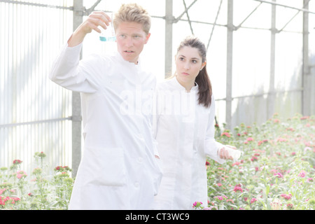 Scientists examining liquid in beaker Stock Photo