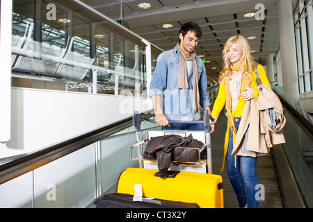 Couple on moving walkway in airport Stock Photo