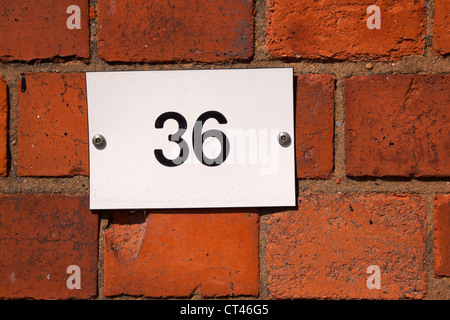 Number '36' on a plate attached to a brick wall Stock Photo