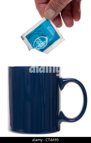 Sprinkling white sugar from a sachet into a blue mug Stock Photo