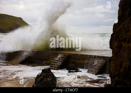 A big wave hits the breakwater at Hope Cove, South Devon Stock Photo