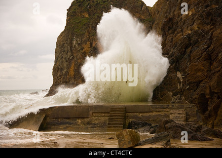 A big wave hits the breakwater at Hope Cove, South Devon Stock Photo
