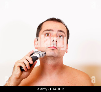 man shaving his beard off with an electric razor Stock Photo