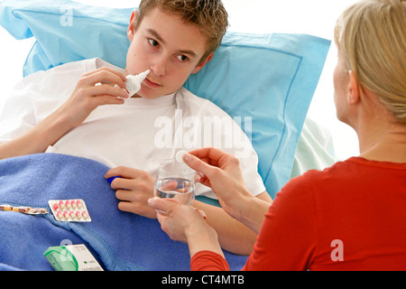 ADOLESCENT USING NOSE SPRAY Stock Photo